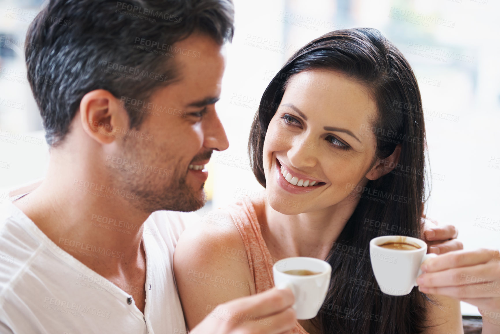 Buy stock photo Shot of a young couple grabbing a cup of coffee together