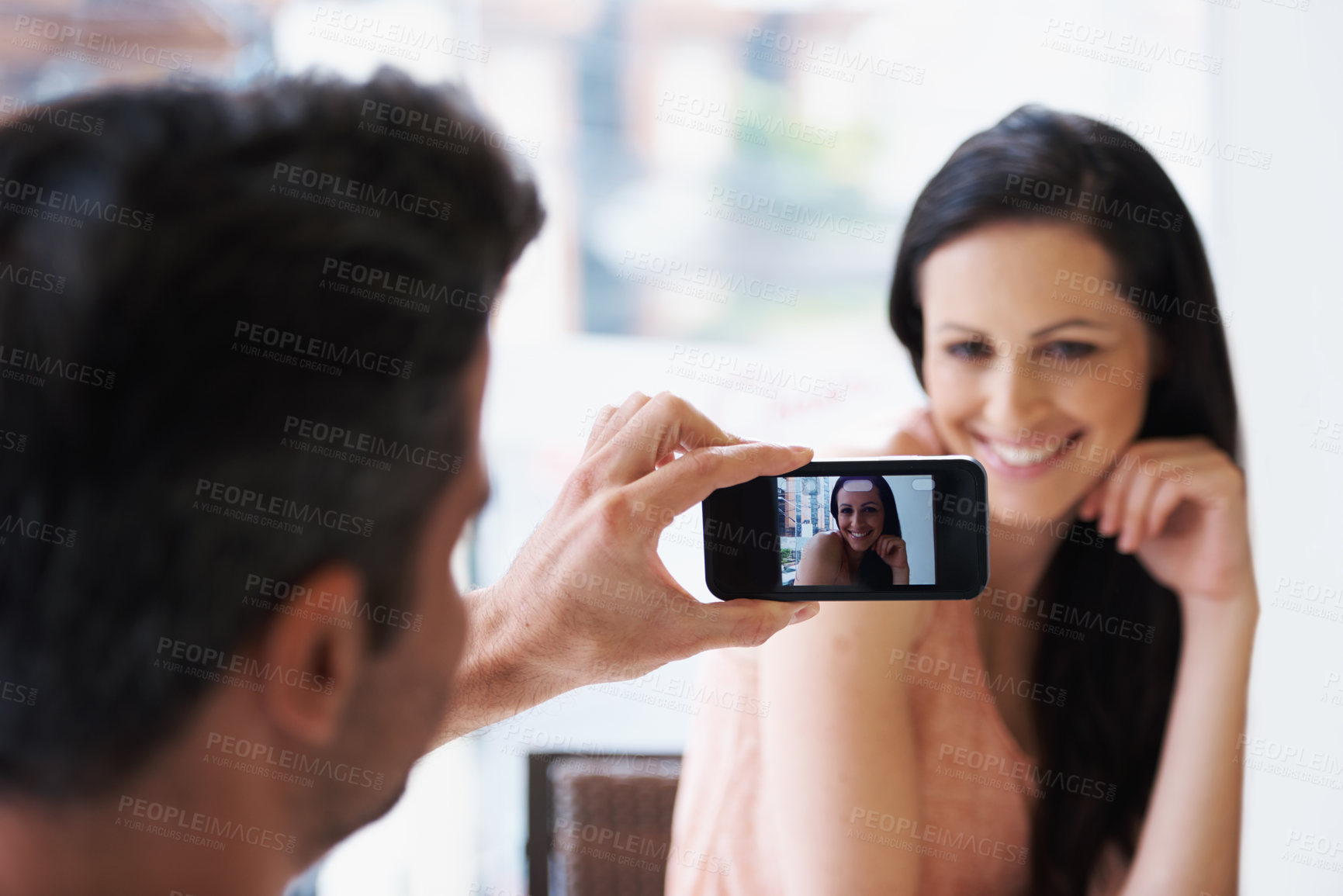 Buy stock photo Happy couple, taking picture and love in coffee shop on vacation and wife smile for husband on romantic date. Man, cellphone and capture image of woman in restaurant and sweet memory on honeymoon