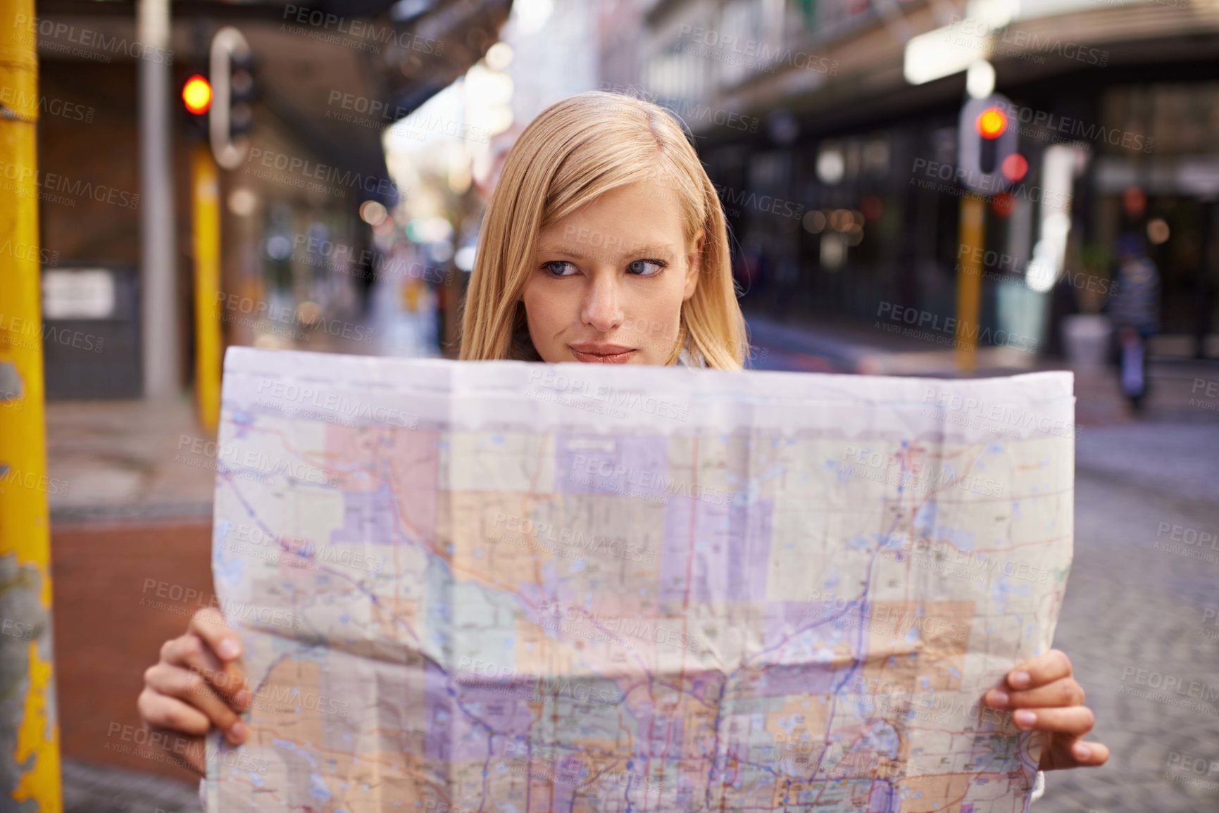 Buy stock photo Shot of a young woman holding a map while touring abroad