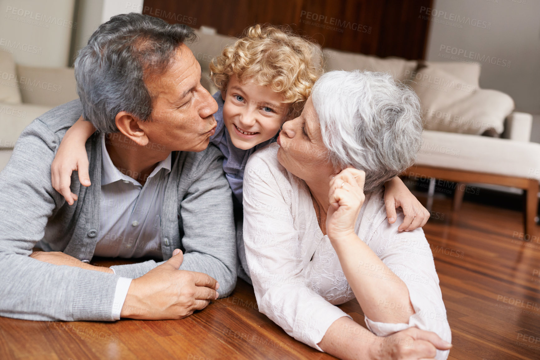 Buy stock photo Floor, portrait or grandparents kiss a happy kid playing or hugging with love or care in family home. Smile, grandma or old man relaxing or bonding to enjoy time with child or cute boy in retirement