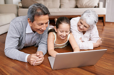 Buy stock photo Laptop, floor or grandparents with happy girl for movie streaming online subscription in retirement at home. Child, relaxing together or grandmother watching funny comedy videos with a senior old man