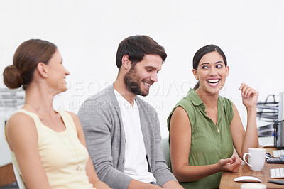 Buy stock photo Shot of three work colleagues enjoying a conversation in the office