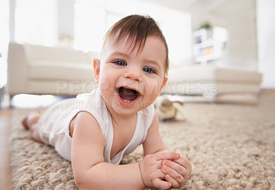 Buy stock photo Happy, baby portrait and tummy time on floor, laugh and play in living room. Teething, child development and growth learning to crawl by laying on stomach, curious kid in white vest for at home fun