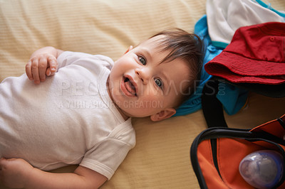 Buy stock photo Happy baby, lying down and smiling on bed, home and wide awake for clothing change. Infant boy, bottle and looking up in white body vest, innocent and cheerful portrait of child relaxing in nursery 