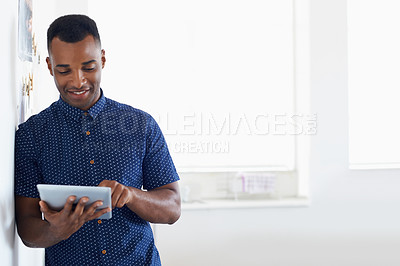 Buy stock photo A young African-American man working on a digital tablet
