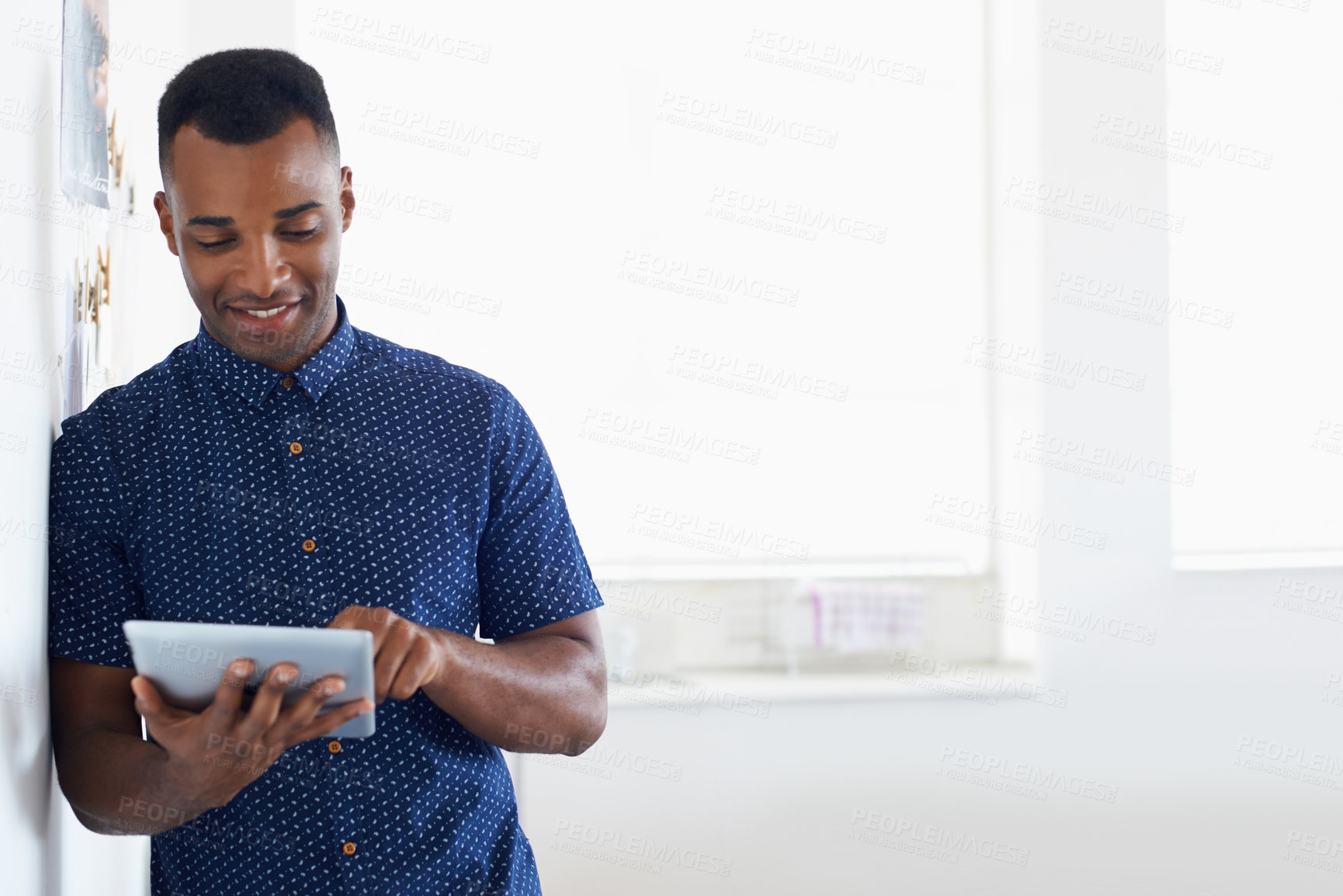 Buy stock photo A young African-American man working on a digital tablet