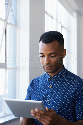 Buy stock photo Businessman, tablet and internet at window for communication, online search or networking in office. Entrepreneur, african employee and serious with technology for corporate email or planning at work