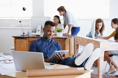 Buy stock photo Smile, business and black man on tablet for research, communication or reading email on internet in startup office. Technology, happy professional and creative architect with legs on desk to relax