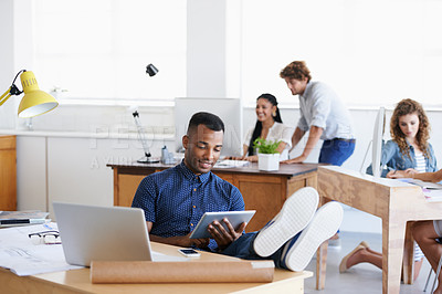 Buy stock photo Workplace, laptop and tablet with man as architect with blueprints in office of creative company with colleagues. Male person, relax and working with technology, connection and internet for projects