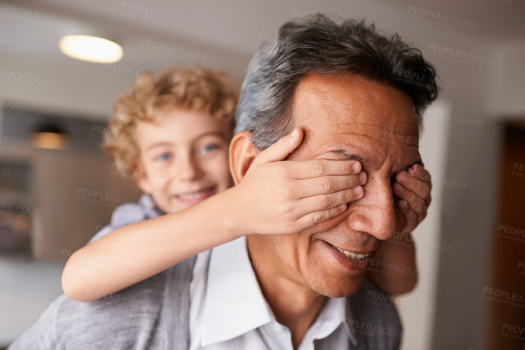 Buy stock photo Shot of a playful little boy and his grandfather