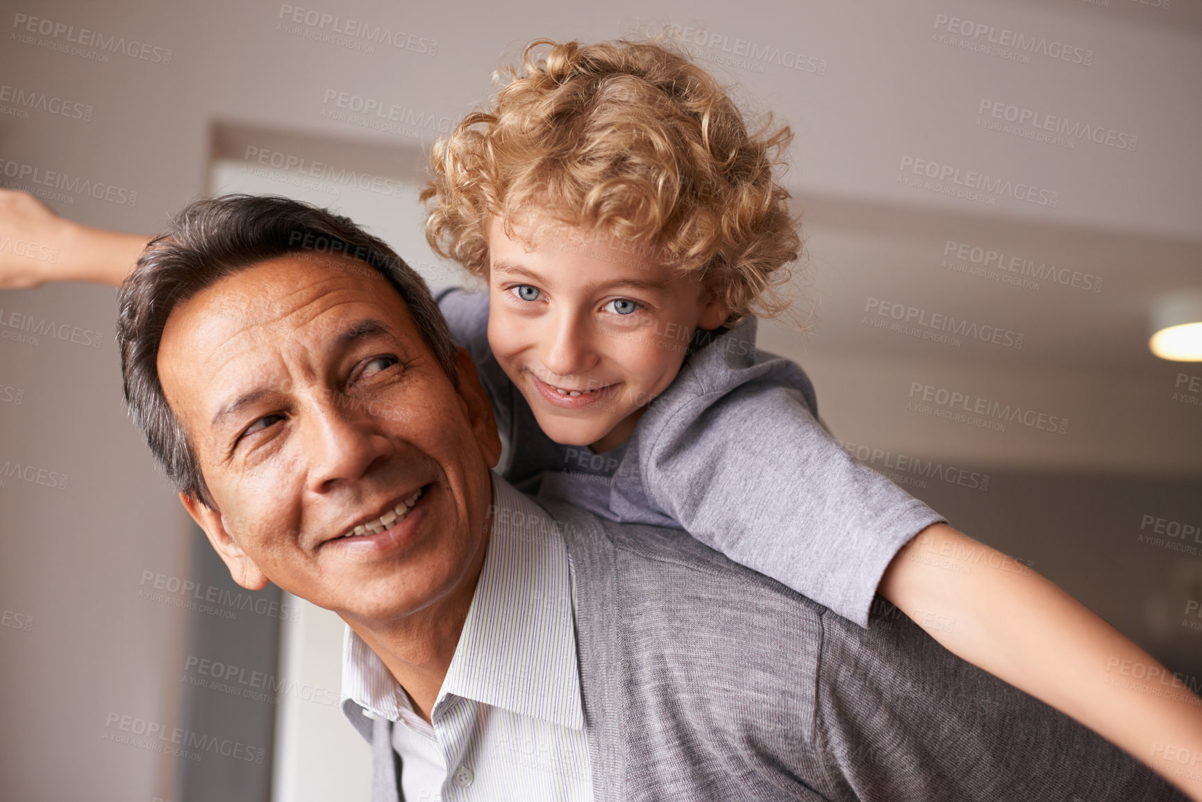 Buy stock photo Portrait, man and child with piggyback for multiracial family, bonding and together at home. Happy, retired male person and boy with embrace, care and love for fun, cheerful and play in retirement