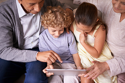 Buy stock photo Family, children and grandparents pointing with tablet for entertainment or social media on sofa at home. Grandma, grandpa and showing kids interaction with technology for bonding or game at house