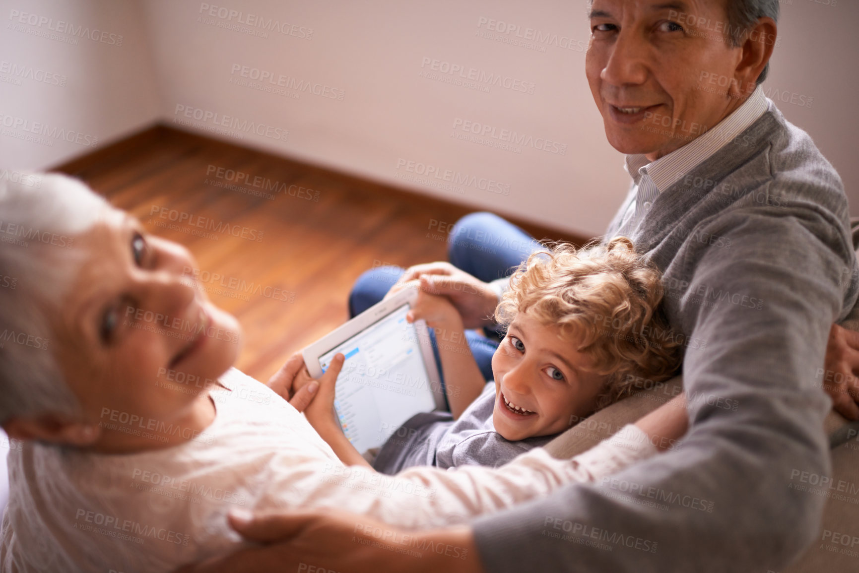Buy stock photo Child, grandparents and tablet or portrait for online technology or communication, teaching or connection. Elderly couple, retirement and kid with internet learning in apartment, together or bonding