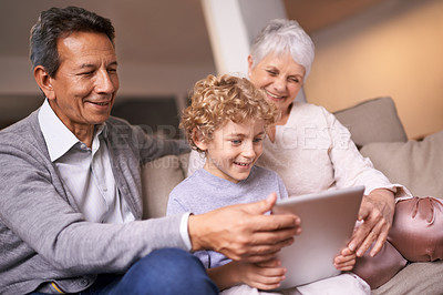 Buy stock photo Happy family, grandparents and little boy with tablet for entertainment, social media or research on sofa at home. Grandma, grandpa and child smile on technology for online search or movie at house