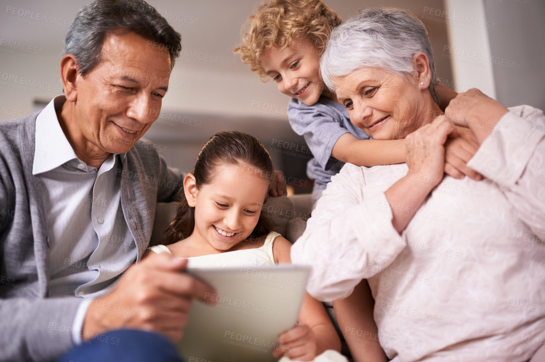 Buy stock photo Happy family, grandparents and children with tablet on sofa for entertainment or social media at home. Grandma, grandpa and kids with smile, hug and love on technology for bonding or game at house