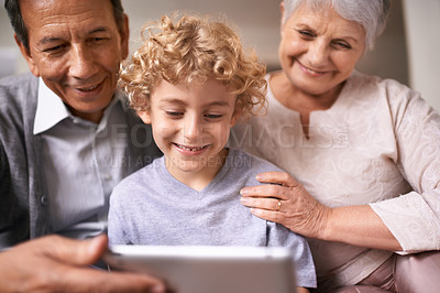 Buy stock photo Happy family, grandparents and child with tablet for entertainment, social media or research on sofa at home. Grandma, grandpa and little boy smile on technology for online search or movie at house