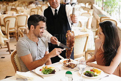 Buy stock photo Happy couple, date and dining with kebab of waiter serving, meat or slices on romantic dinner at table. Young man or woman with chef, skewer or food for meal, eating or enjoying service at restaurant