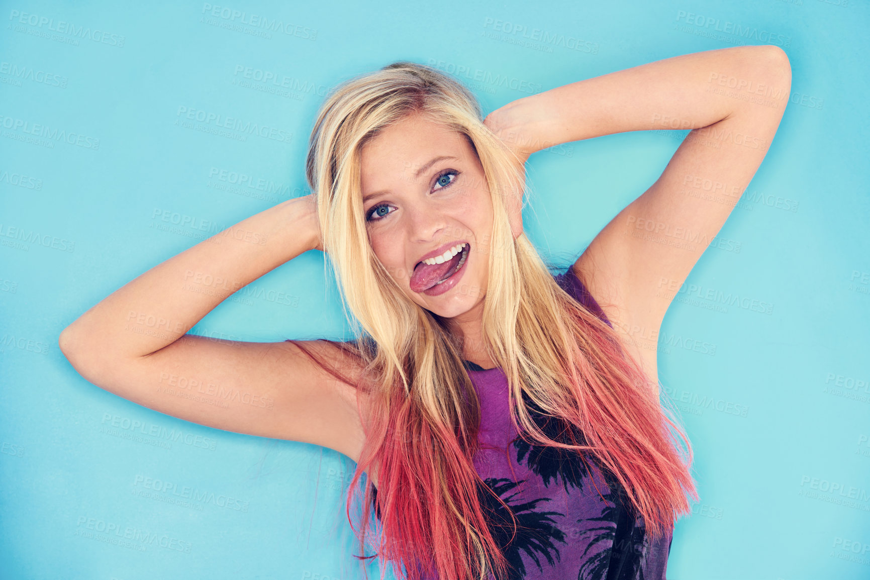 Buy stock photo Portrait, blue background and crazy gen z girl with smile in studio, unique and punk with outfit. Youth, fun and female person with funny face, relax and cool with clothes for fashion in summer