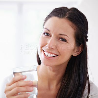 Buy stock photo Cropped portrait of an attractive young woman drinking a glass of water