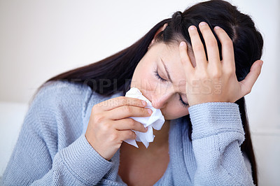 Buy stock photo Cropped shot of a young woman holding a tissue and looking sad