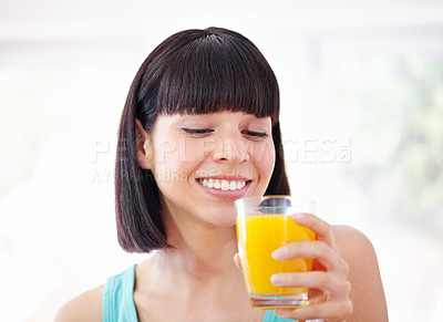 Buy stock photo A young woman drinking orange juice