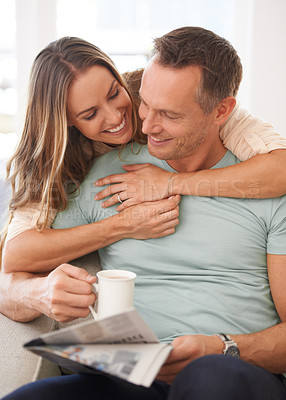 Buy stock photo Happy couple, care and newspaper with coffee in home and bonding together with love in marriage. Man, woman and hug by cappuccino for reading headlines, sofa and romantic indoor to relax on weekend