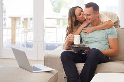 Buy stock photo Newspaper, hug and happy couple on sofa with love, kiss and affection at home for relaxing holiday or morning news. Mature woman with partner or people reading paper, laptop and drink coffee on couch