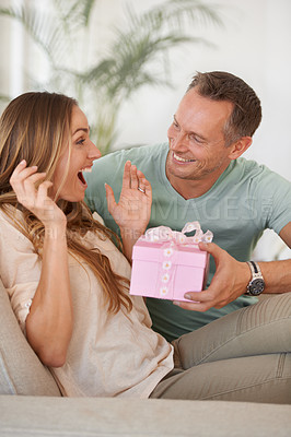 Buy stock photo Man, present and surprise for woman with wow reaction, happy people with love and trust at home. Anniversary, birthday or event, couple with secret gift box with shock for celebration and romance