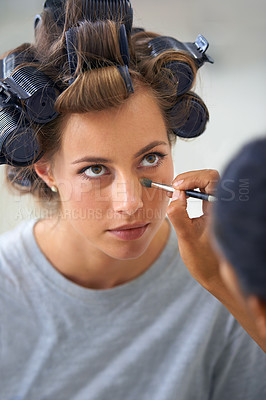 Buy stock photo Beauty, makeup or hair curlers and woman at salon, getting ready with professional stylist backstage. Haircare, curling and eyeliner with face of celebrity or actress at hairdresser behind the scenes