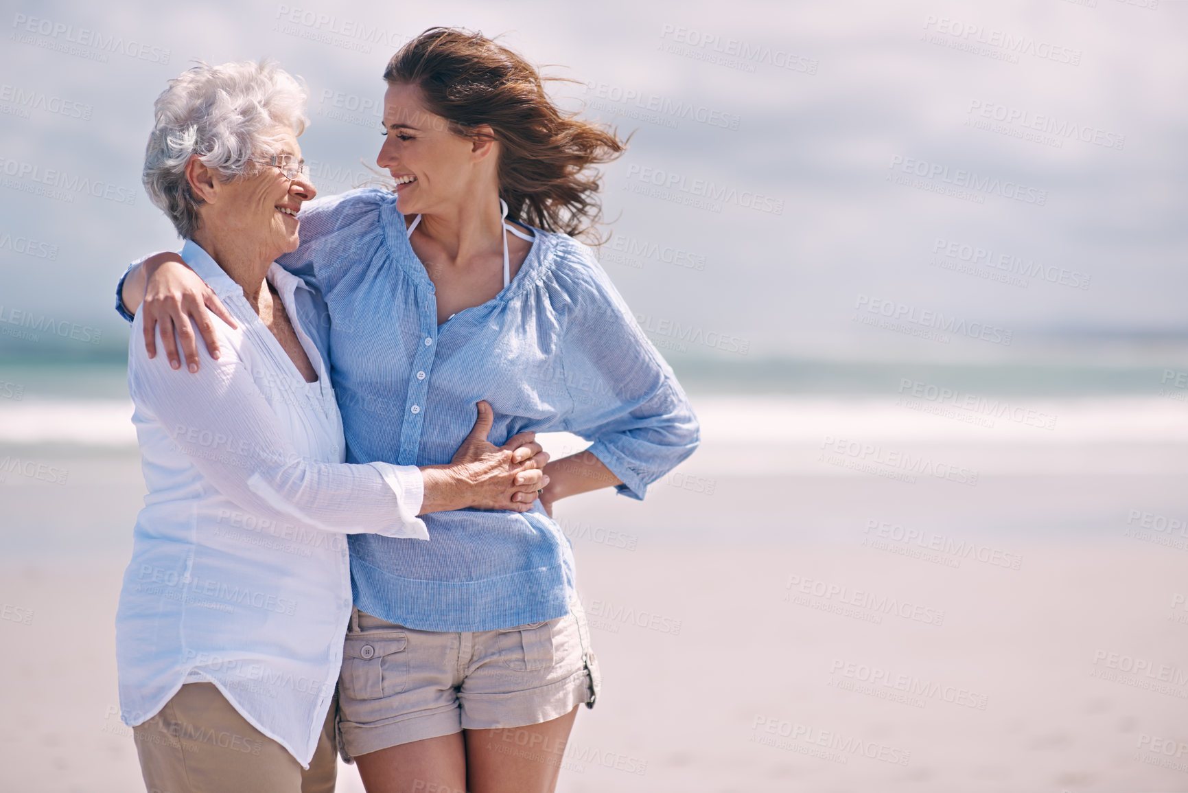 Buy stock photo Beach, embrace and senior woman with young woman on the or at the beach together and outdoors. Mockup, happy and hugging elderly woman with adult daughter or at sea for leisure and travel 