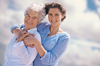 Buy stock photo Woman, senior mother and portrait by sky with hug, happiness, love or smile for mothers day on vacation. Elderly lady, daughter or happy with care, bond or outdoor by clouds for holiday in retirement