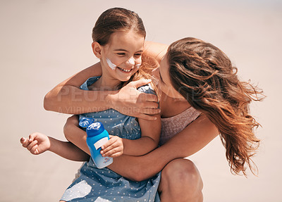 Buy stock photo Shot of a young mother embracing her daughter at the beach