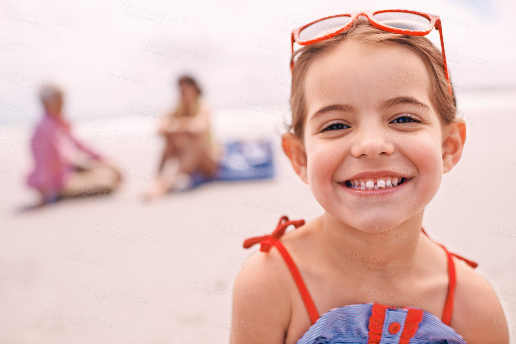 Buy stock photo Portrait, relax and little girl on beach in summer with family for travel, holiday or vacation. Face, smile and sunshine with happy young child on sand by ocean or sea for tropical weekend getaway