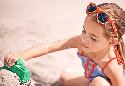 Buy stock photo Girl, toys and building sandcastle on the beach with shape or block for fun summer, holiday or weekend in nature. Female person, child or kid playing and enjoying sand construction by the ocean coast