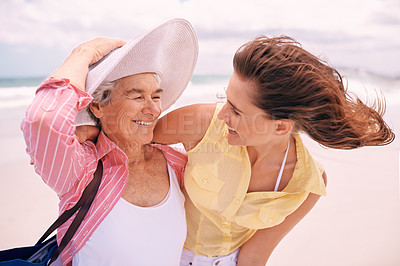 Buy stock photo Senior, mother and woman with beach wind or vacation bonding on tropical island or holiday, happiness or retirement. Old person, daughter and hat at Florida seaside or travel tourism, relax or trip
