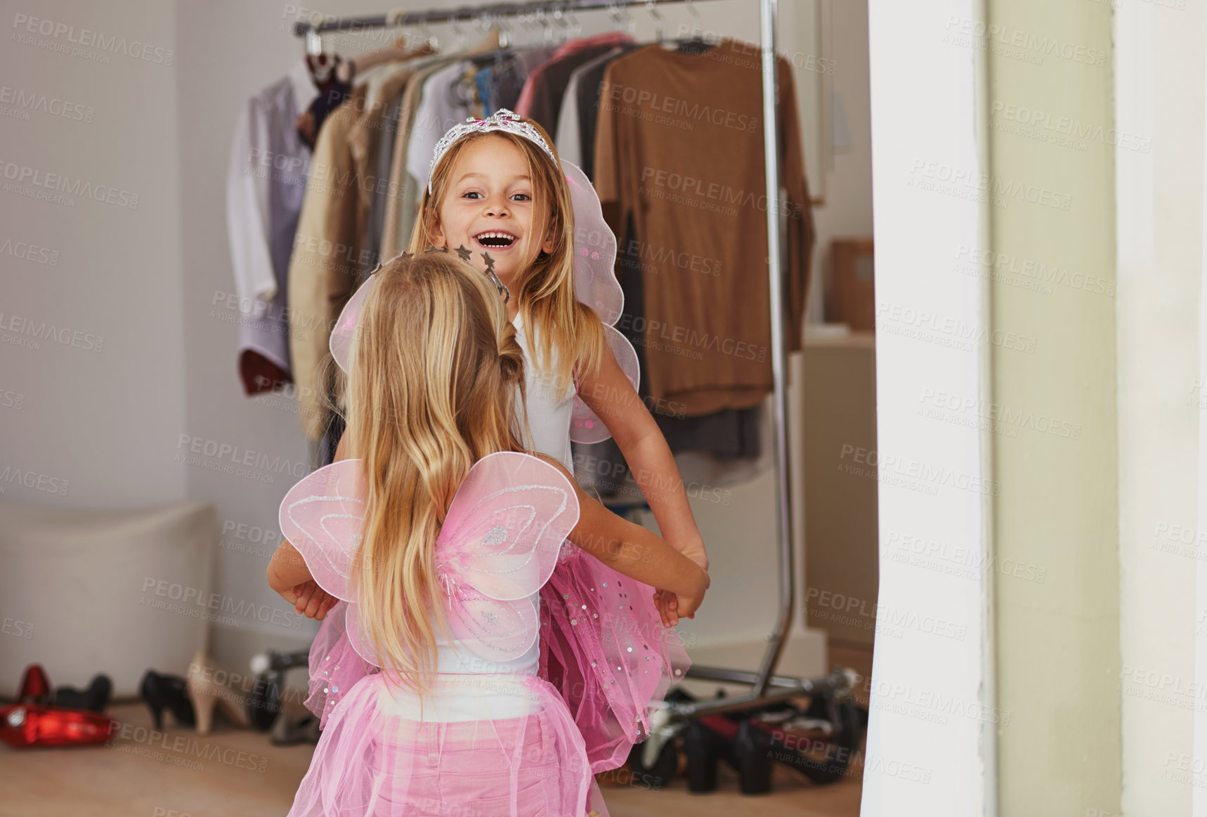 Buy stock photo Girl, sister and face with fairy costume in bedroom of home for dress up, fantasy play and tiara with dancing. Family, children and holding hands with princess outfit for bonding, rear view and wings