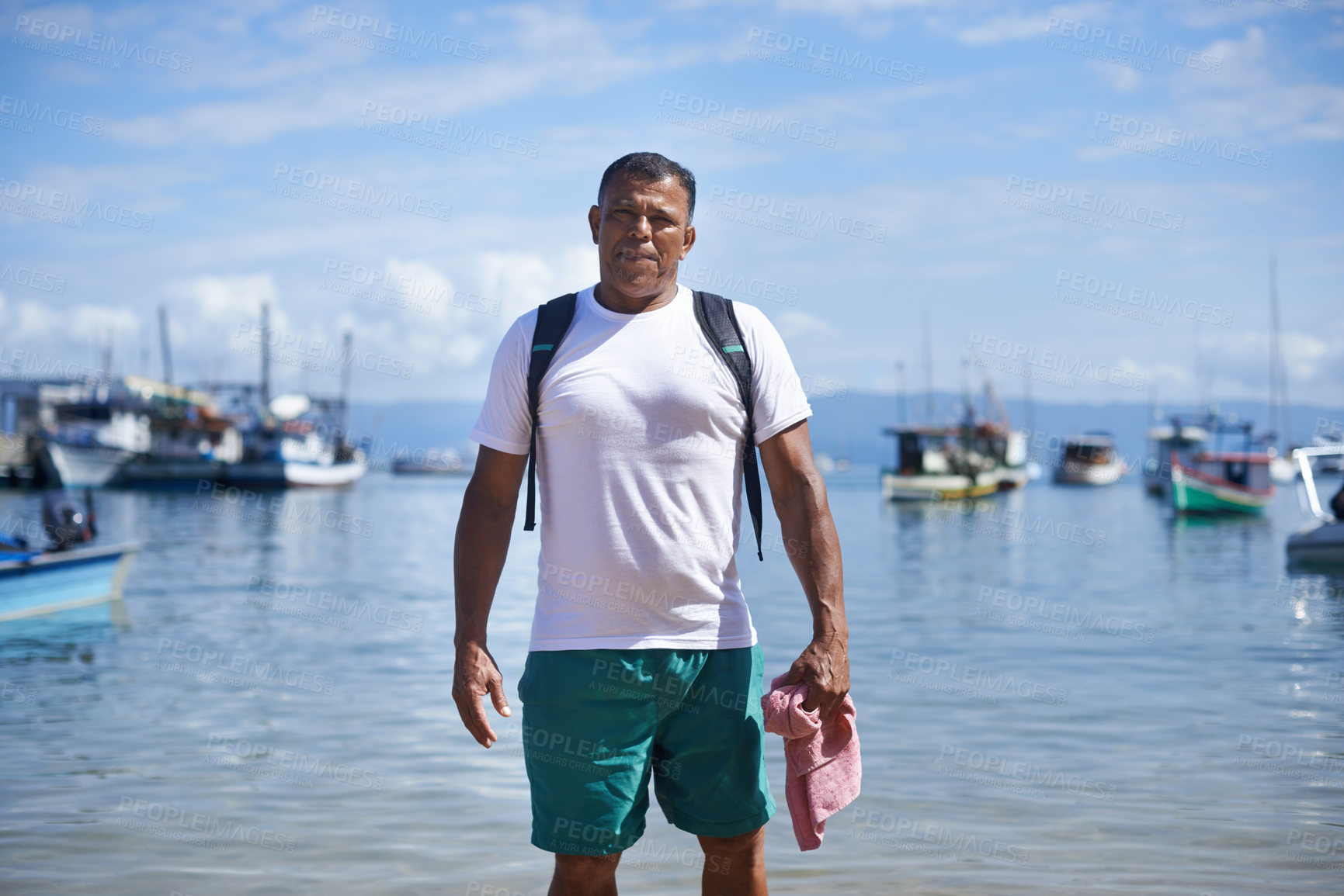 Buy stock photo Portrait of a fisherman standing in shallow water in the harbor