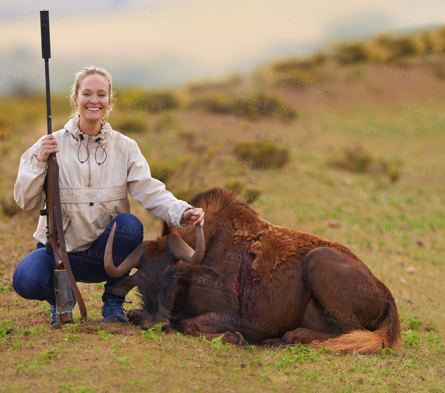 Buy stock photo Shot of a female hunter kneeling beside her kill