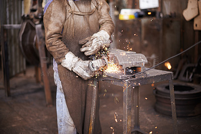 Buy stock photo A man grinding metal in a workshop