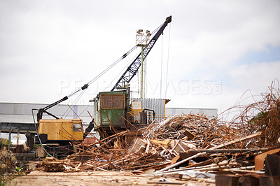 Buy stock photo Shot of a crane at work in a dumpsite