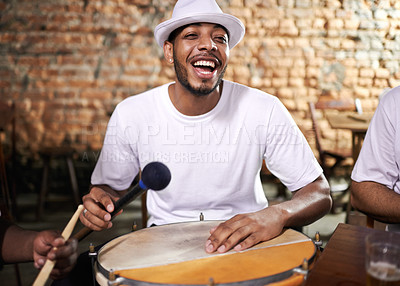 Buy stock photo Cropped shot of a young ethnic playing drums indoors
