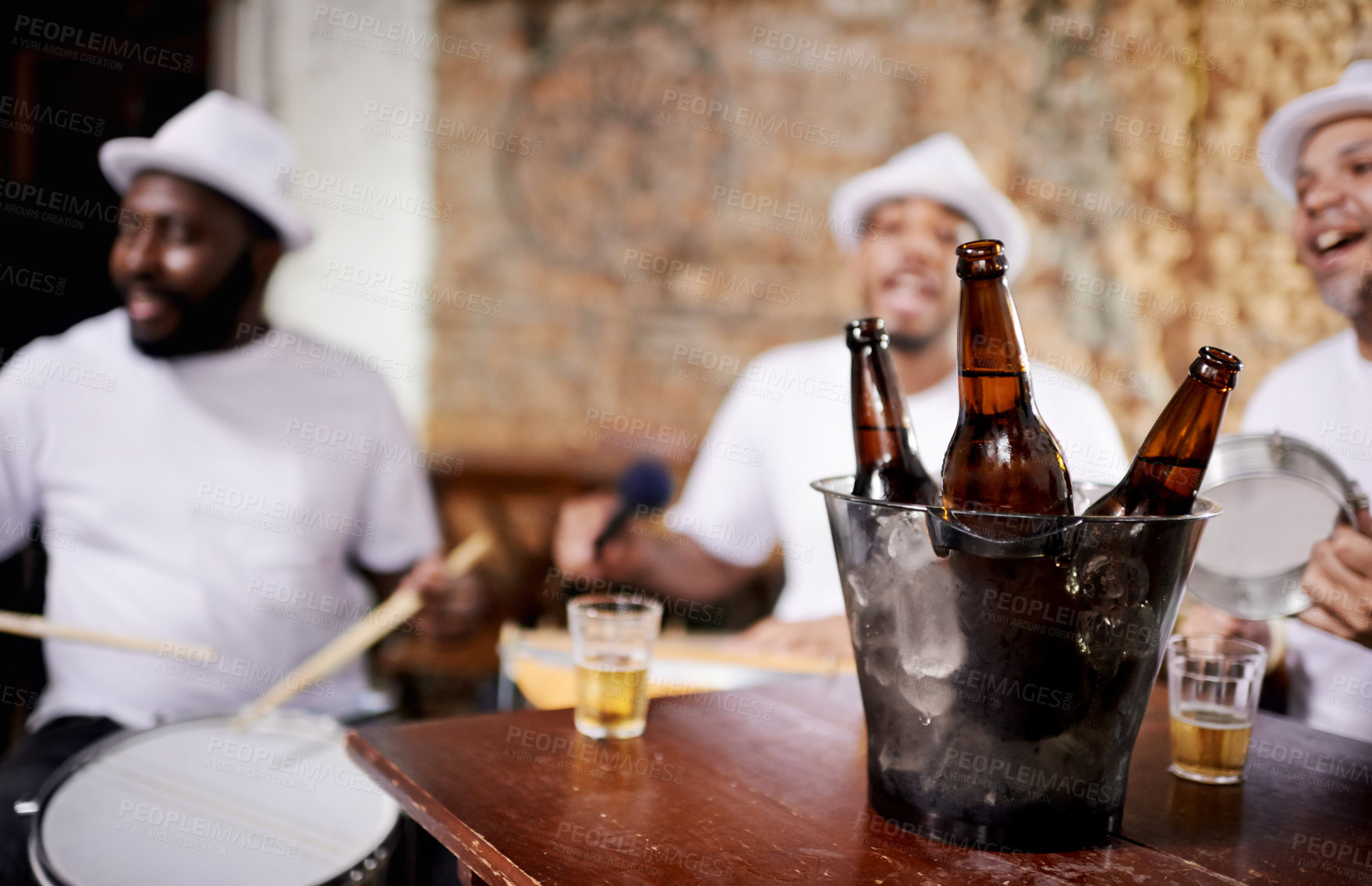 Buy stock photo Musician, band and friends with drink, men and happy for drums, performance and party with alcohol. Group, artist and singing with bottle, beer and relax in pub for social event in Rio de Janeiro