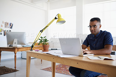 Buy stock photo A handsome young man working at his desk
