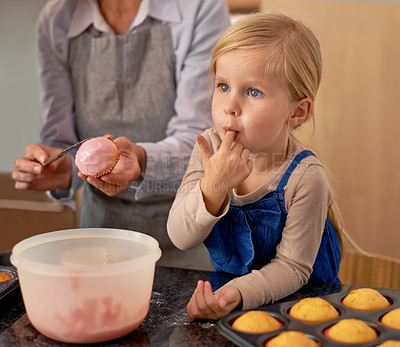 Buy stock photo Child, baking and eating icing in kitchen for cupcake decoration or hungry for sweet snack, helping or ingredients. Teamwork, girl and finger for recipe taste in home for youth bonding, food or fun