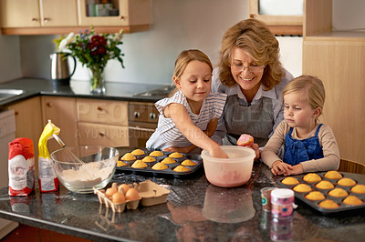 Buy stock photo Grandmother, children and baking cupcakes or helping with icing decorations or learning creativity, bonding or teamwork. Woman, siblings and sweet treats or teaching with ingredients, snack or fun