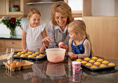 Buy stock photo Grandma, children and smile for teaching, baking and decorating for family, play and bonding at home. Happy, pensioner and girl with cupcake, laugh and icing for creative fun together in kitchen