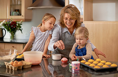 Buy stock photo Grandma, kid and baking with teaching, smile and decorating for cheerful bonding together at home. Happy, pensioner or girl child with cupcake, laugh or icing for creative, playful or fun in kitchen