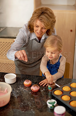 Buy stock photo Grandmother, child and baking cupcakes or sprinkles with icing decorations or learning creativity, bonding or teamwork. Female person, girl and sweet treats or teaching with ingredients, snack or fun