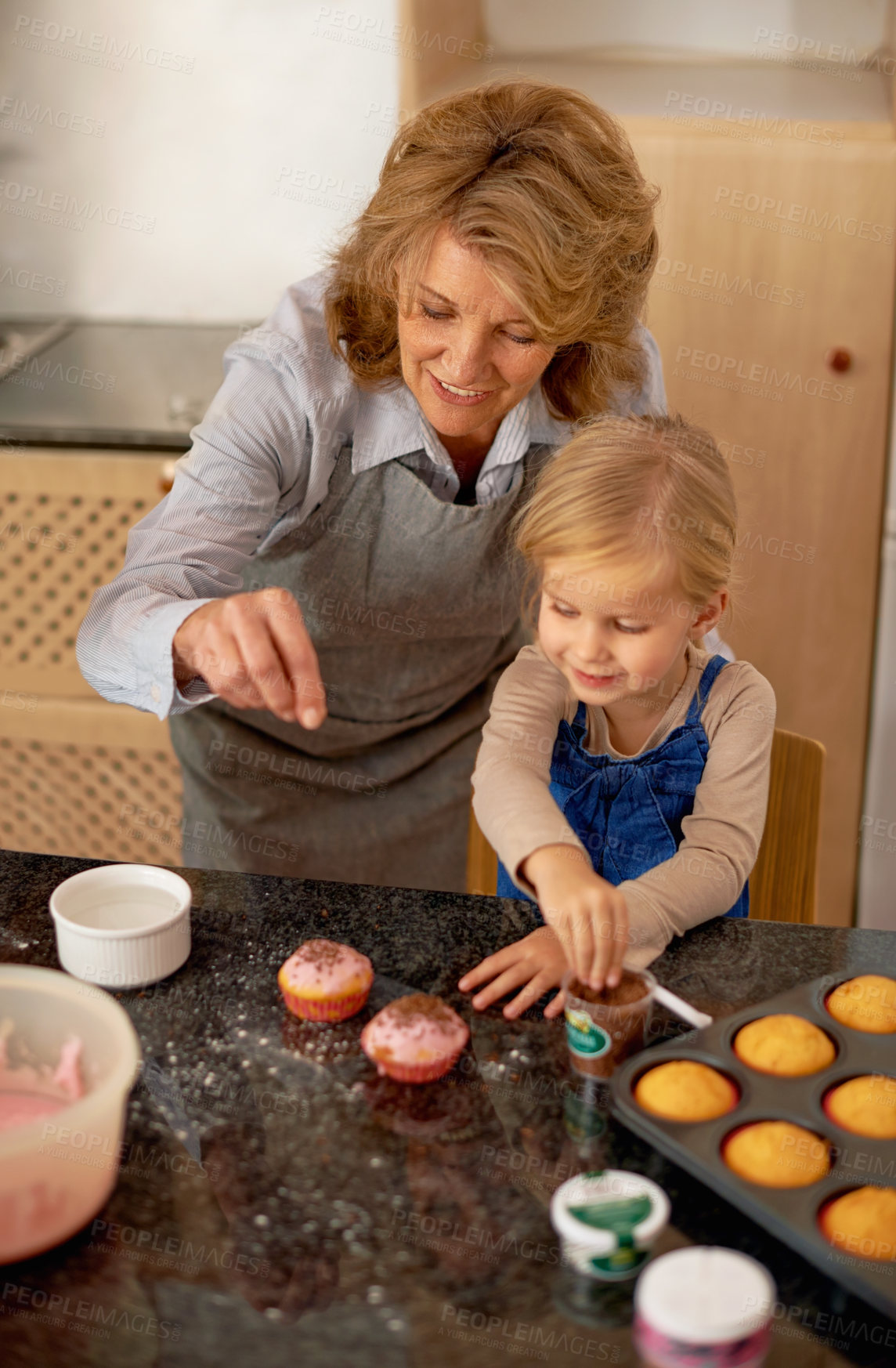 Buy stock photo Grandmother, child and baking cupcakes or sprinkles with icing decorations or learning creativity, bonding or teamwork. Female person, girl and sweet treats or teaching with ingredients, snack or fun