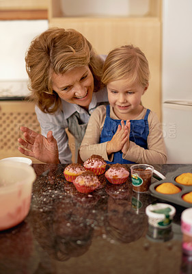 Buy stock photo Woman, child and cupcake sprinkles for baking decoration in kitchen for learning support or sweet snack, proud or ingredients. Grandmother, girl and icing recipe at home for teaching, help or happy